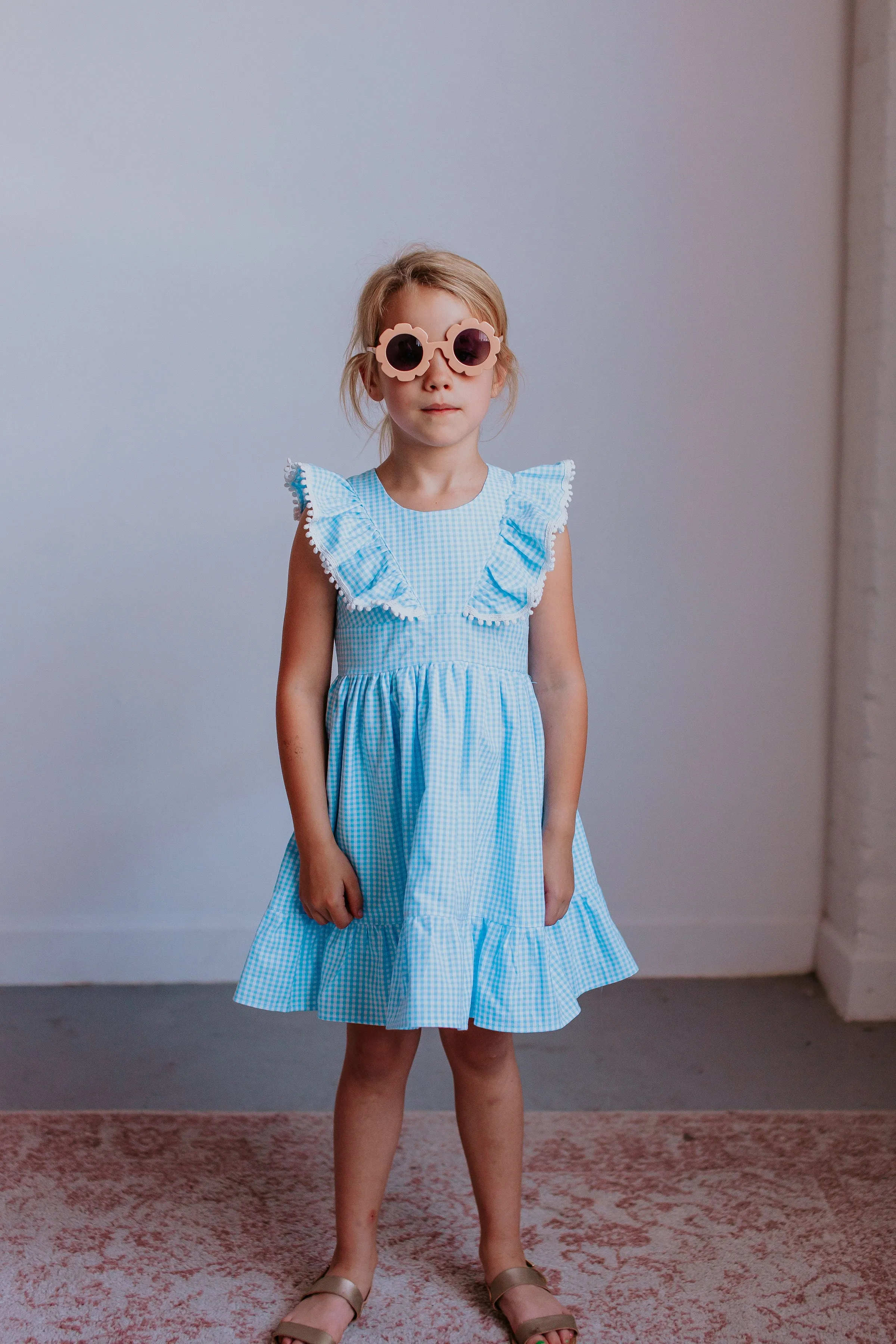 Little Girl's Blue Gingham Pinafore Dress with Pom Pom Trim