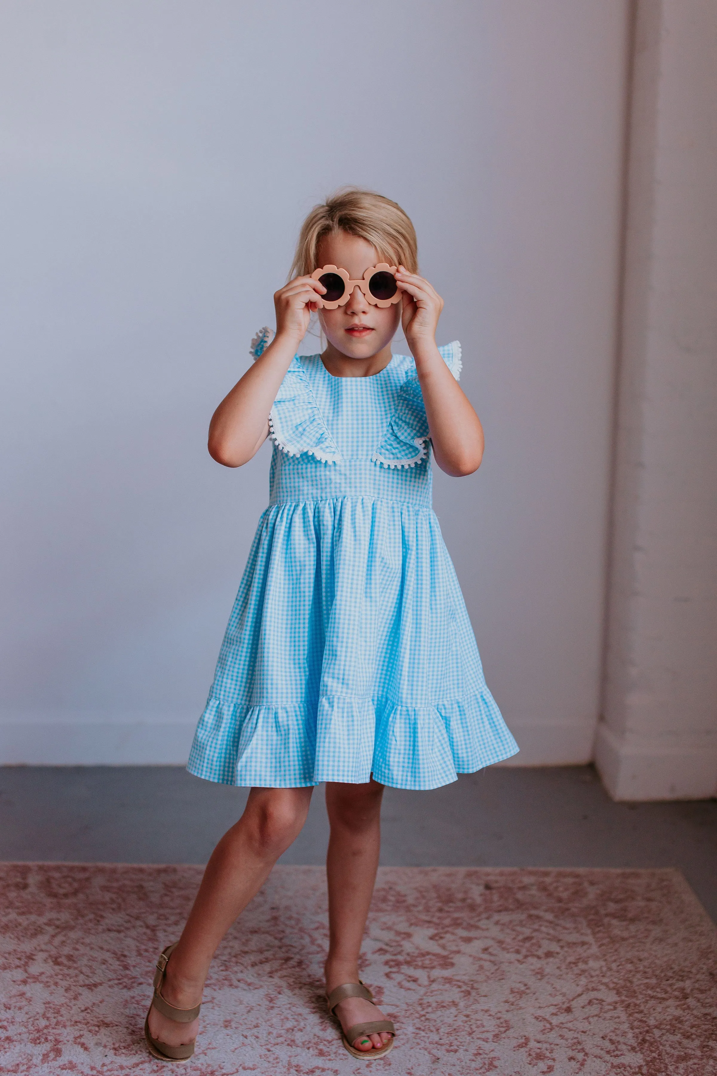 Little Girl's Blue Gingham Pinafore Dress with Pom Pom Trim