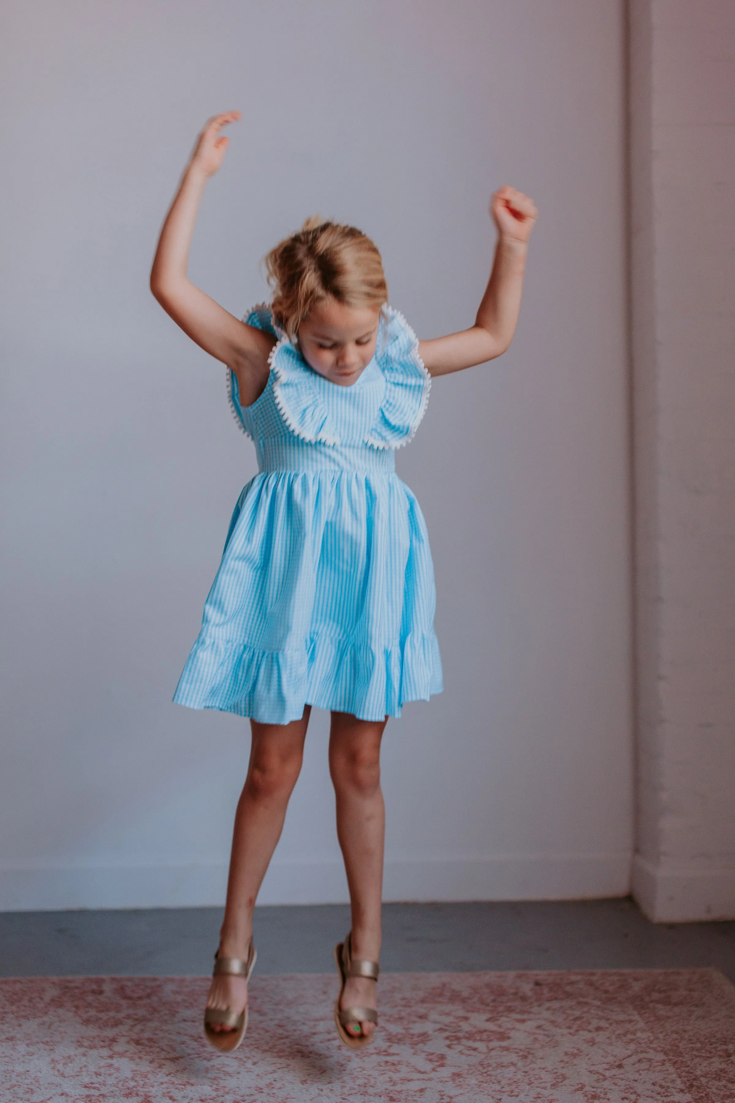 Little Girl's Blue Gingham Pinafore Dress with Pom Pom Trim